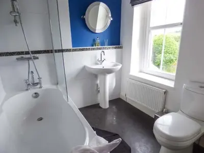 a bathroom with a white toilet and a sink at 2 West View in Holker