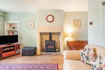 a living room with a fireplace and a tv at Pye Hall Cottage in Silverdale