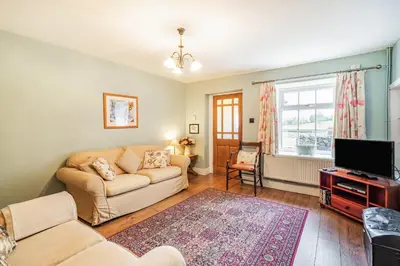 a living room with a couch and a tv at Pye Hall Cottage in Silverdale