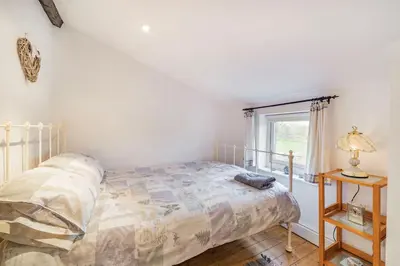 a bedroom with a bed and a window at Pye Hall Cottage in Silverdale