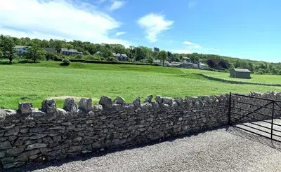 a stone wall with a bunch of head stones at Pye Hall Cottage in Silverdale