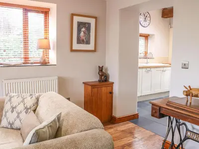 a living room with a couch and a table at Barn Owl Cottage At Crook Hall Farm in Mawdesley
