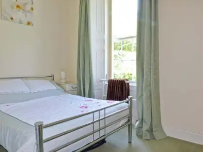 a bedroom with a bed and a large window at 2 Cark House in Holker