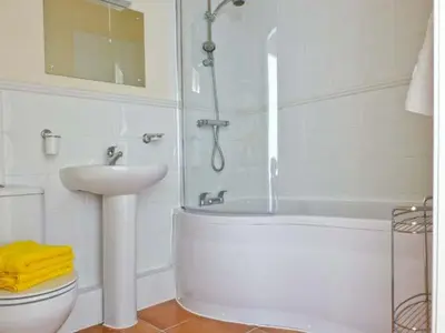a bathroom with a sink and a tub and a toilet at 2 Cark House in Holker