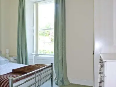 a bedroom with a bed and a large window at 2 Cark House in Holker