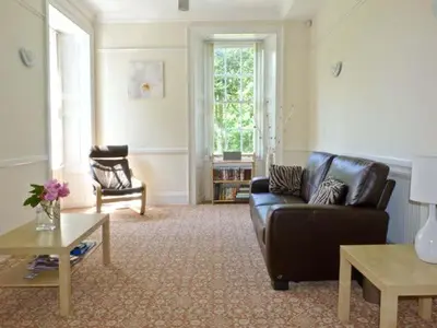 a living room with a leather couch and a table at 2 Cark House in Holker