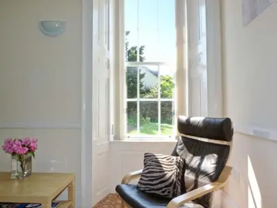 a living room with a chair and a window at 2 Cark House in Holker