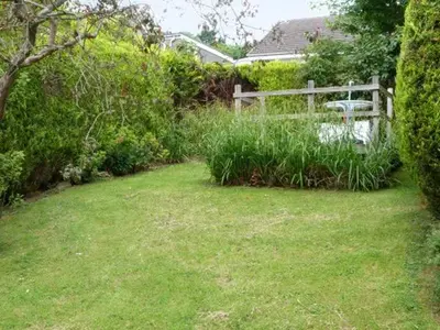 a yard with a wooden fence and a bench at Baytree Apartment in Grange Over Sands