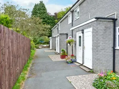 a house with a fence next to a driveway at Baytree Apartment in Grange Over Sands