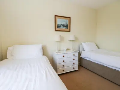 a bedroom with two beds and a dresser with two lamps at Silverdale Mount in Grange Over Sands
