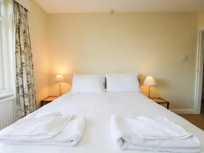 a bedroom with a white bed with towels on it at Silverdale Mount in Grange Over Sands