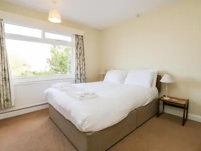 a bedroom with a large bed with a window at Silverdale Mount in Grange Over Sands