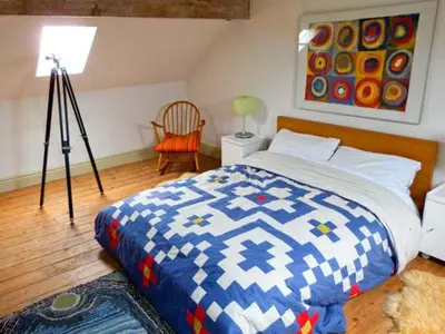 a bedroom with a blue and white bed and a lamp at Raceside Farm in Silecroft