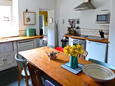 a kitchen with a wooden table with flowers on it at Raceside Farm in Silecroft
