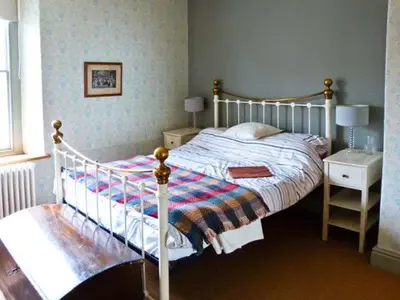 a bedroom with a white bed and a nightstand with a bed sidx sidx sidx at Raceside Farm in Silecroft