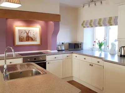 a kitchen with a sink and a counter top at Stone Mouse Cottage in Harrop Fold