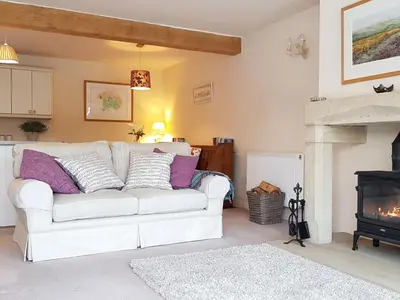 a living room with a white couch and a fireplace at Stone Mouse Cottage in Harrop Fold