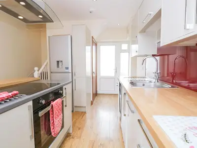 a kitchen with a sink and a stove top oven at Fernleigh Cottage in Holker
