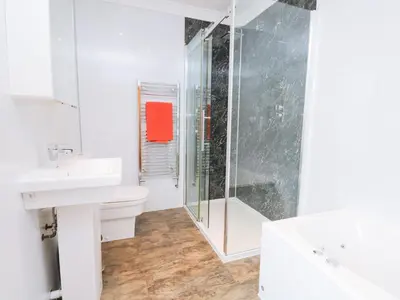 a bathroom with a shower and a toilet and a sink at Fernleigh Cottage in Holker