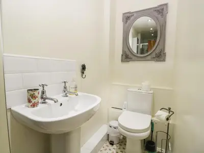a bathroom with a sink and a toilet and a mirror at 14 Low Row in Holker