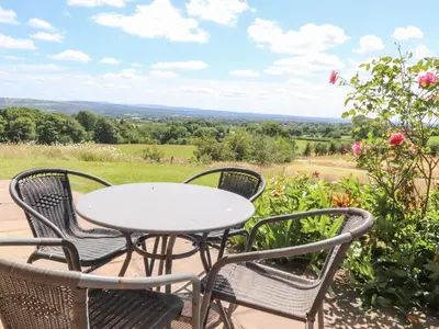 a table and chairs on a patio with a view at Cottam Cottage Farm in Longridge
