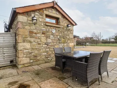 a stone building with a table and chairs at Deekswood in Pilling