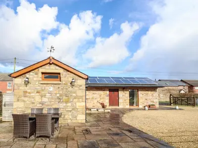 a stone church with solar panels on the roof at Deekswood in Pilling