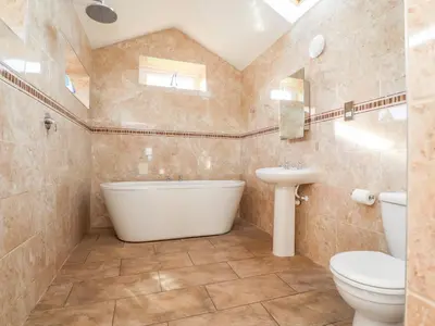 a bathroom with a tub and a toilet and a sink at Deekswood in Pilling