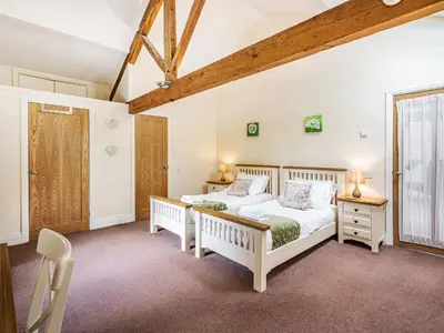 a bedroom with two beds and a window at Hay Barn in Burton in Lonsdale