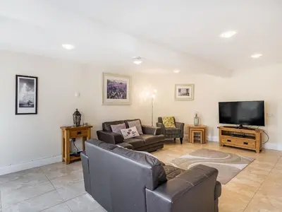 a living room with couches and a flat screen tv at Hay Barn in Burton in Lonsdale