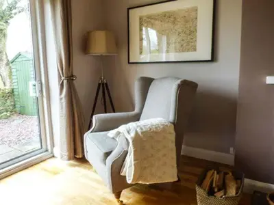 a living room with a chair and a window at Bridleway Cottage in Wennington