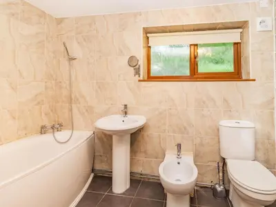 a bathroom with a sink and a toilet and a bath tub at Wild Duck Lodge in Rufford