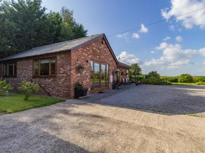 a brick house with a driveway in front of it at Wild Duck Lodge in Rufford
