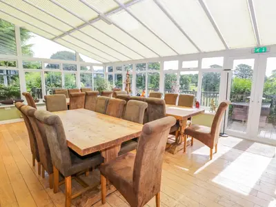 a dining room with a wooden table and chairs at Eden Lodge in Bardsea