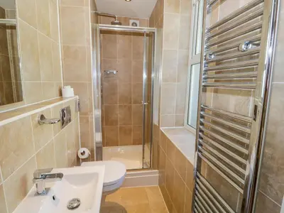 a bathroom with a shower and a toilet and a sink at Eden Lodge in Bardsea