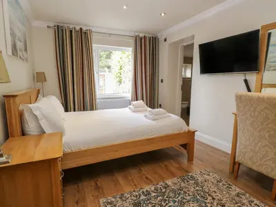 a bedroom with a bed and a tv and a window at Eden Lodge in Bardsea