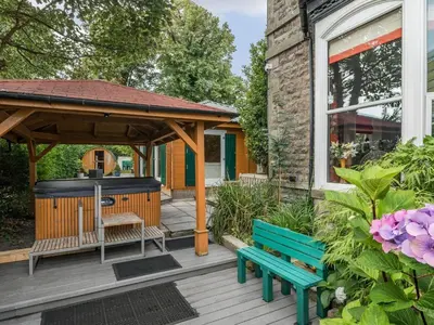 a wooden deck with a gazebo and a bench at Eden Lodge in Bardsea