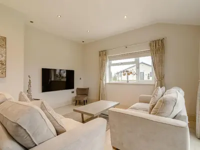 a living room with two white couches and a tv at Sunnyside Shreyas in Wilpshire
