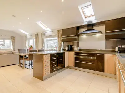 a large kitchen with stainless steel appliances and a couch at Sunnyside Shreyas in Wilpshire