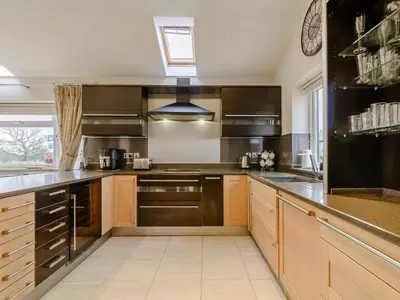 a large kitchen with wooden cabinets and stainless steel appliances at Sunnyside Shreyas in Wilpshire