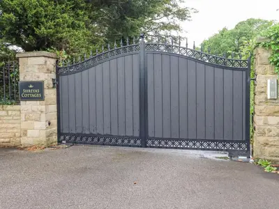 a black gate in a driveway with a stone wall at Sunnyside Shreyas in Wilpshire