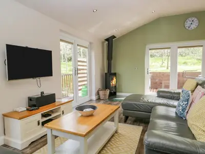 a living room with a couch and a table at Cartmel Lodge in Cartmel