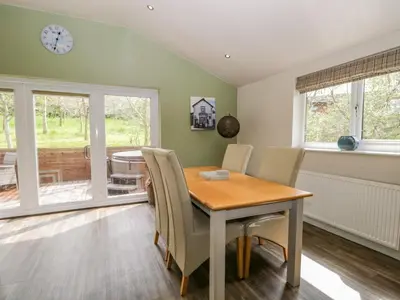 a dining room with a wooden table and chairs at Cartmel Lodge in Cartmel