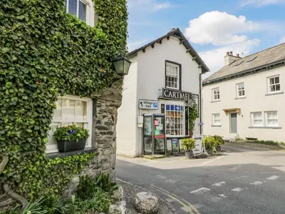 an ivy covered building on a street in a town at Cartmel Lodge in Cartmel