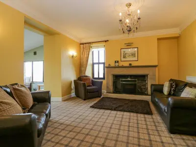 a living room with couches and a fireplace at Groffa Crag Farmhouse in Lowick Green
