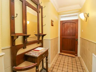 a bathroom with a wooden vanity and a mirror at Groffa Crag Farmhouse in Lowick Green