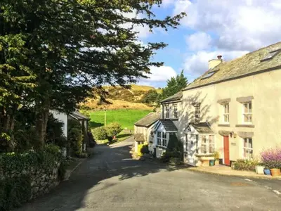 a street in a village with a house and a tree at High House in High Newton