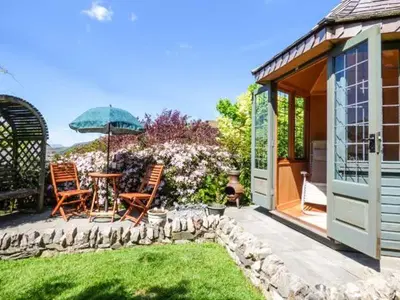 a patio with chairs and a table and an umbrella at High House in High Newton