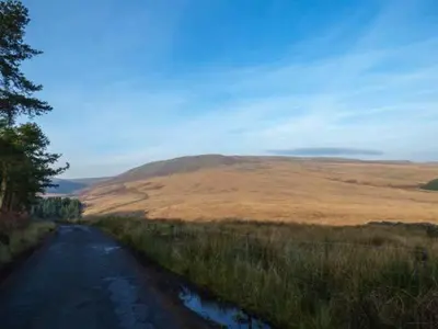a road in the middle of a field with a hill at 88 Regent Street in Waddington