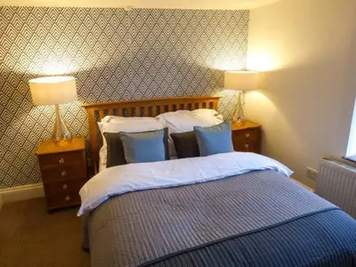 a bedroom with a bed with pillows and two lamps at 88 Regent Street in Waddington